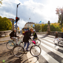 Suojatie Turun Aurasillan vieressä, tietä ylittää useita pyöräilijöitä.