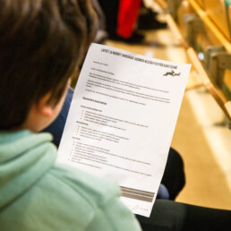 Kuva oppilaasta, jolla paperi kädessä missä opetuspäällikölle valmisteltuja kysymyksiä.
