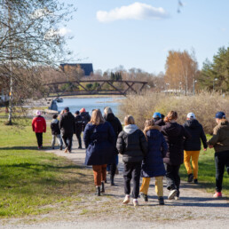 Ryhmä oppilaita ja aikuisia kävelemässä puistossa.