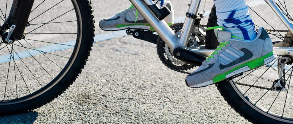 lähikuva jaloista pyörän polkimilla