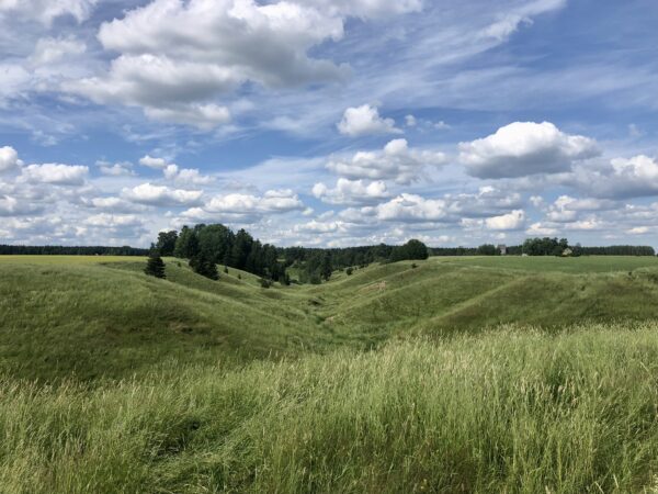 maisemassa peltoa, painanteita, taivasta