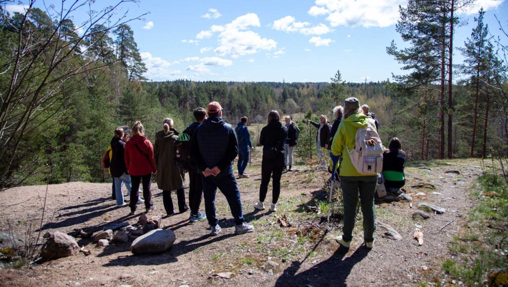 ryhmä ihmisiä ringissä kallion päällä