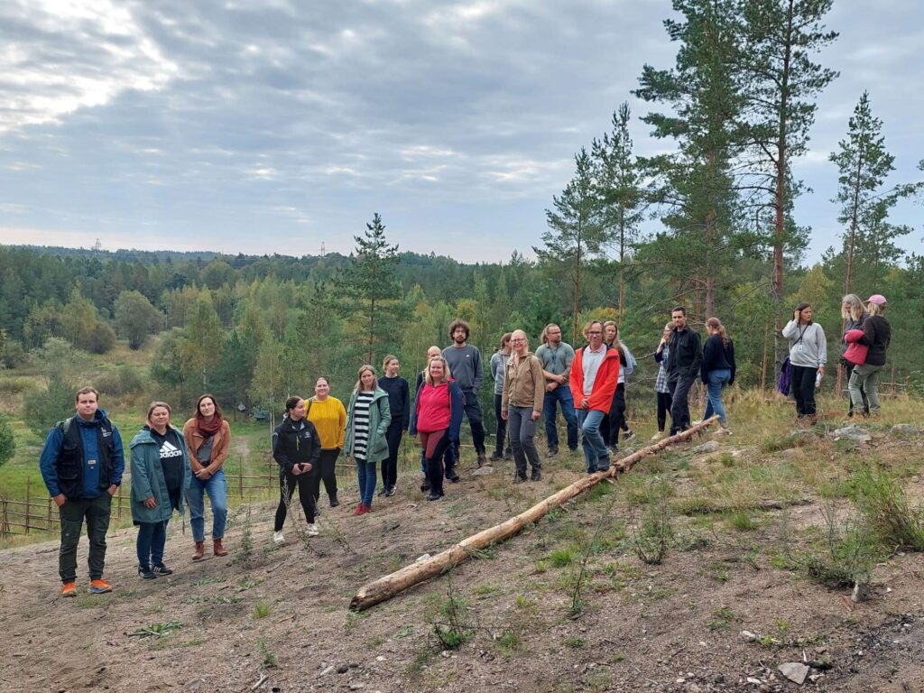 Ihmisiä rivissä harjun päällä