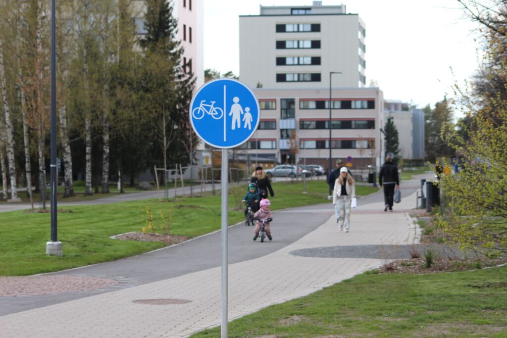kevyen liikenteen väylän liikennemerkki, taustalla kerrostalo