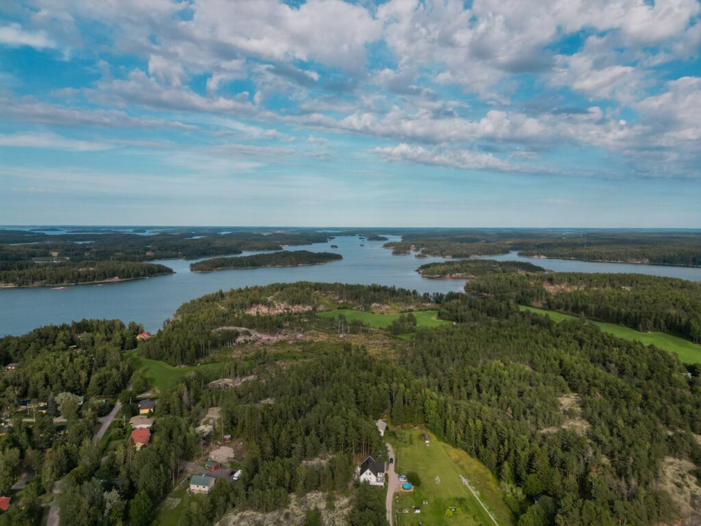 Ilmakuvaa Nauvon rannikolta, merta, metsää ja asutusta.