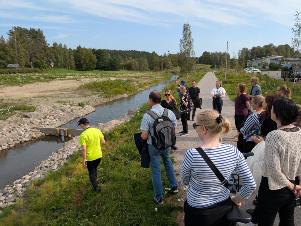 Ihmisiä tutustumassa tulvaniittyihin.