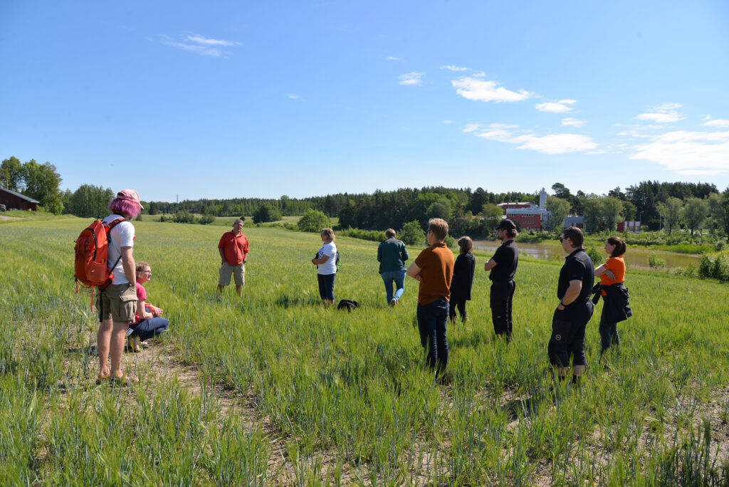 ryhmä ihmisiä seisoo pellolla