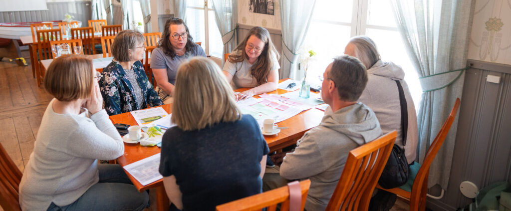 ihmisiä työpajassa pöydän ääressä