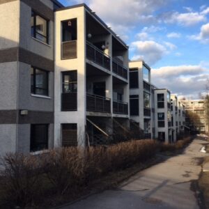 kolmikerroksinen kerrostalo julkisivu, pilviä taivaalla