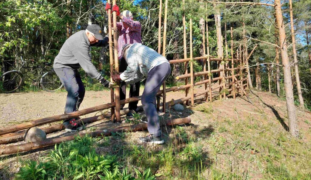 perinneaita, auriko paistaa, kolme ihmistä tekee aitaa