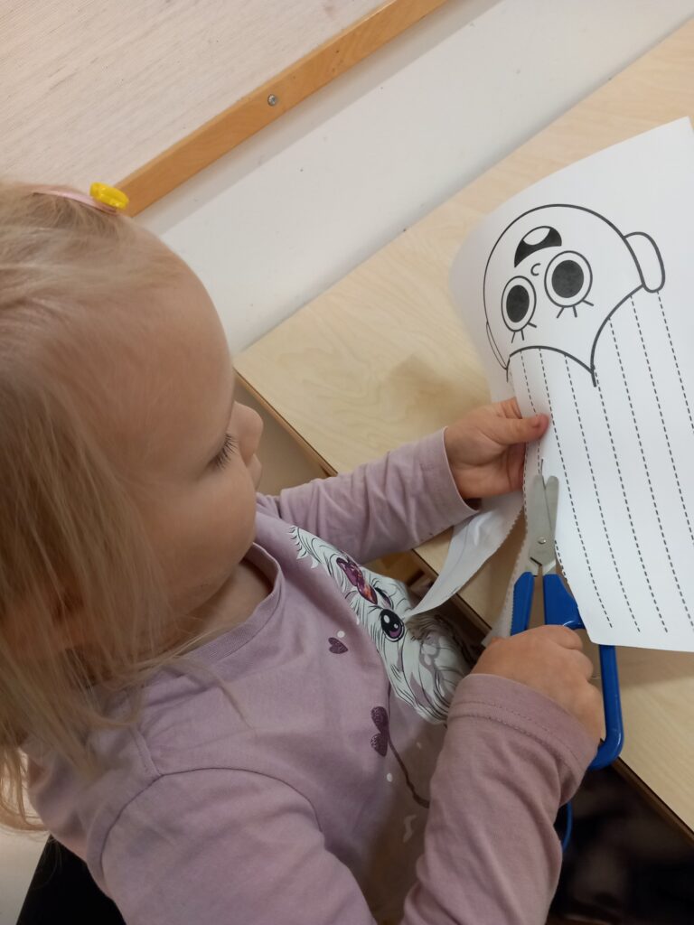 lapsi leikkaa paperia