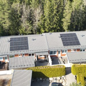 rivitaloja, katoilla aurinkopaneelit, takana metsää