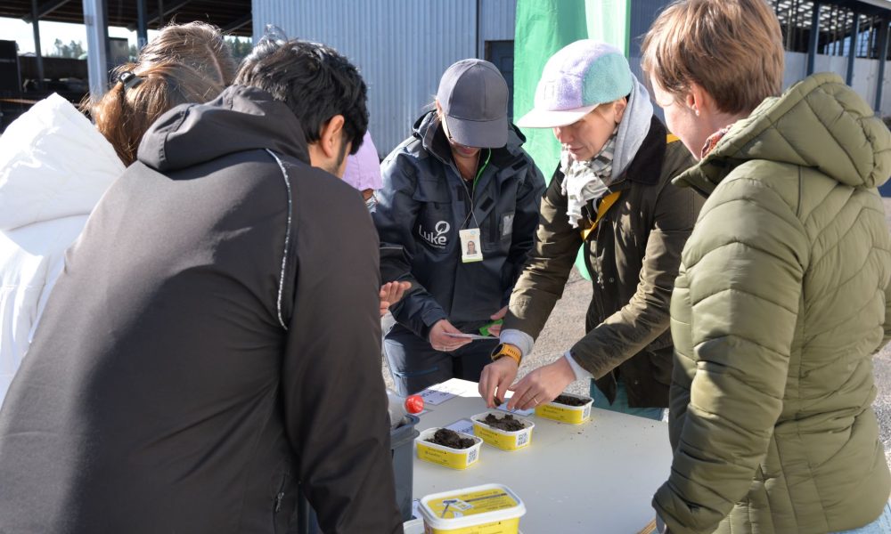 ihmisiä tutkimassa purkeissa olevia maalajeja