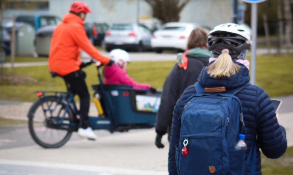 laatikkopyörä ja kävelijä, taustalla kerrostalo