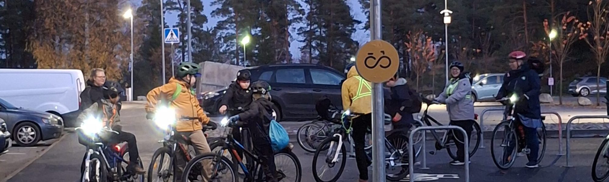 Lapsia pyörien kanssa iltahämärässä