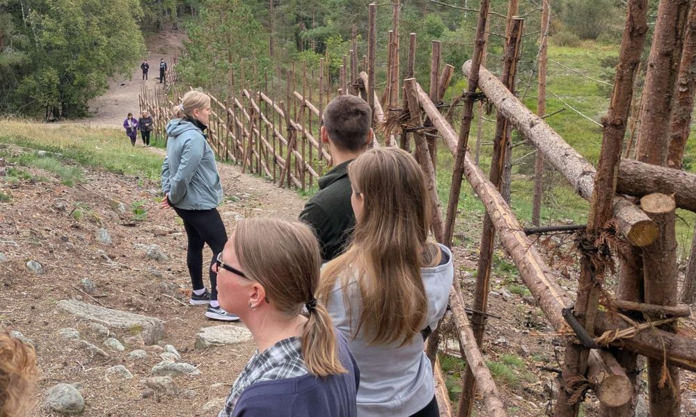 Ihmisiä riukuaidan vieressä