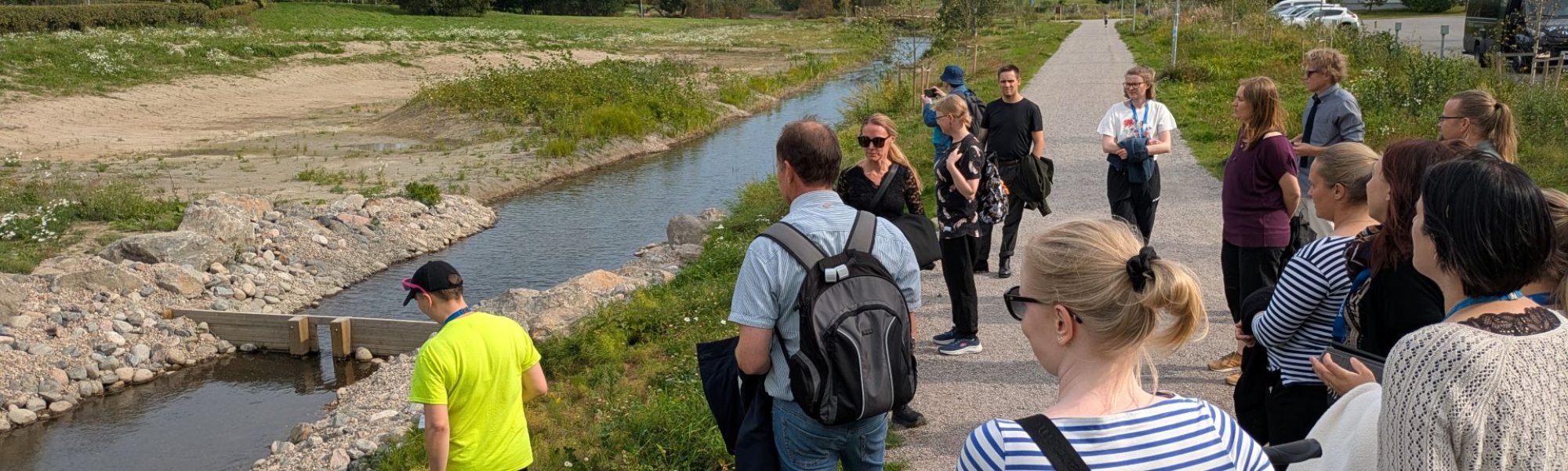 Ihmisiä tutustumassa tulvaniittyihin.